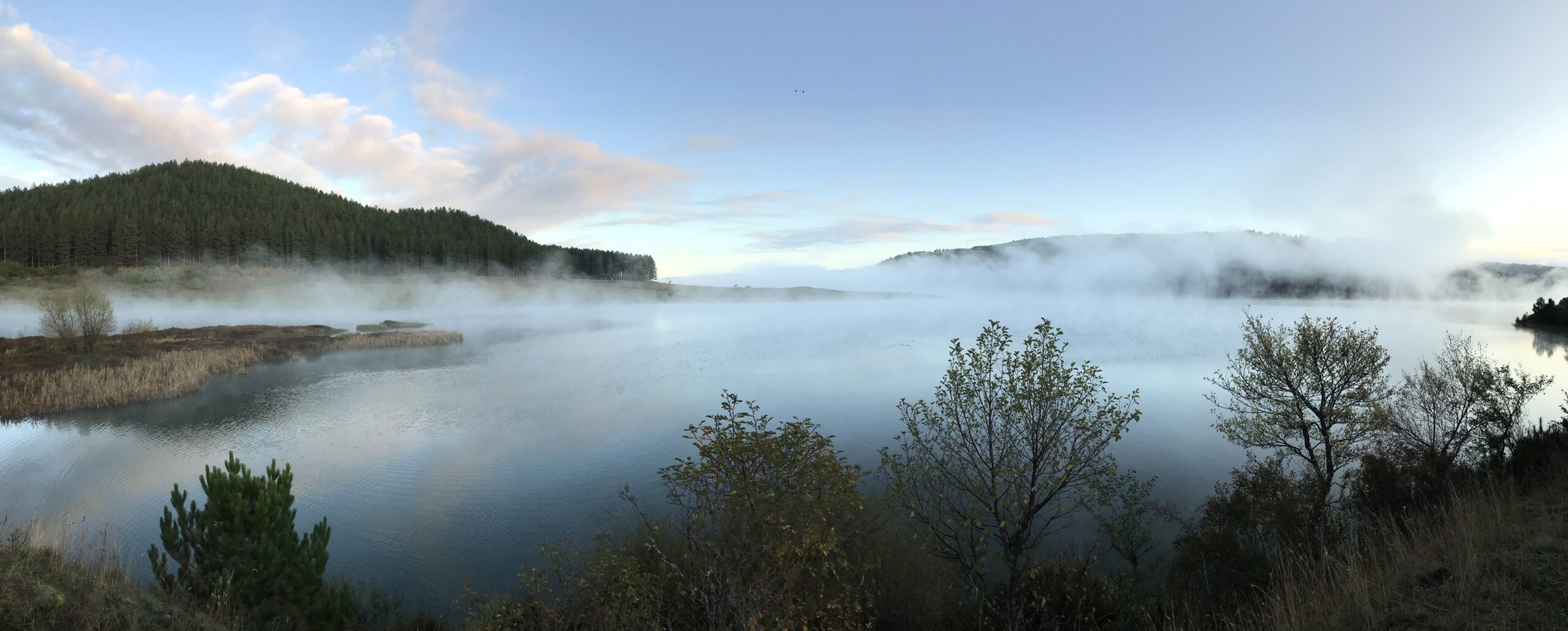 Lago avvolto dalla nebbia all'alba